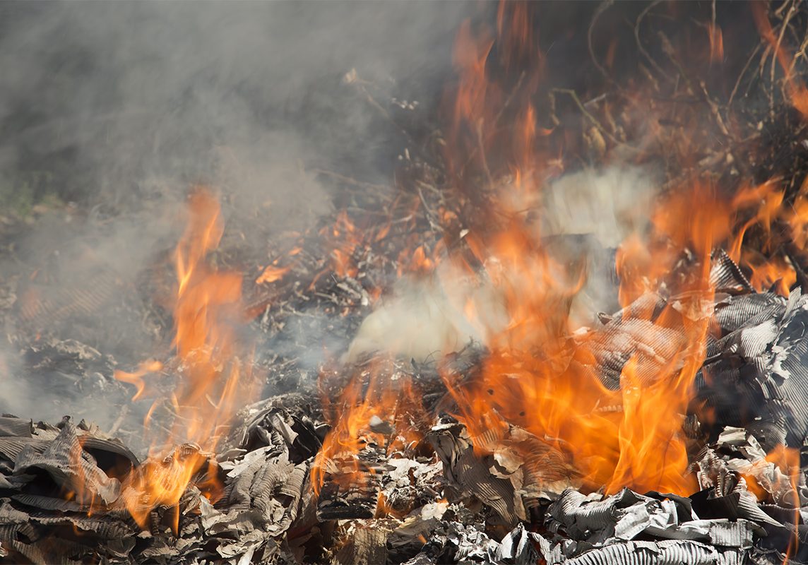 Fire in the yard, illegal burning of garbage. The concept of modern problems of recycling of garbage and ecology.